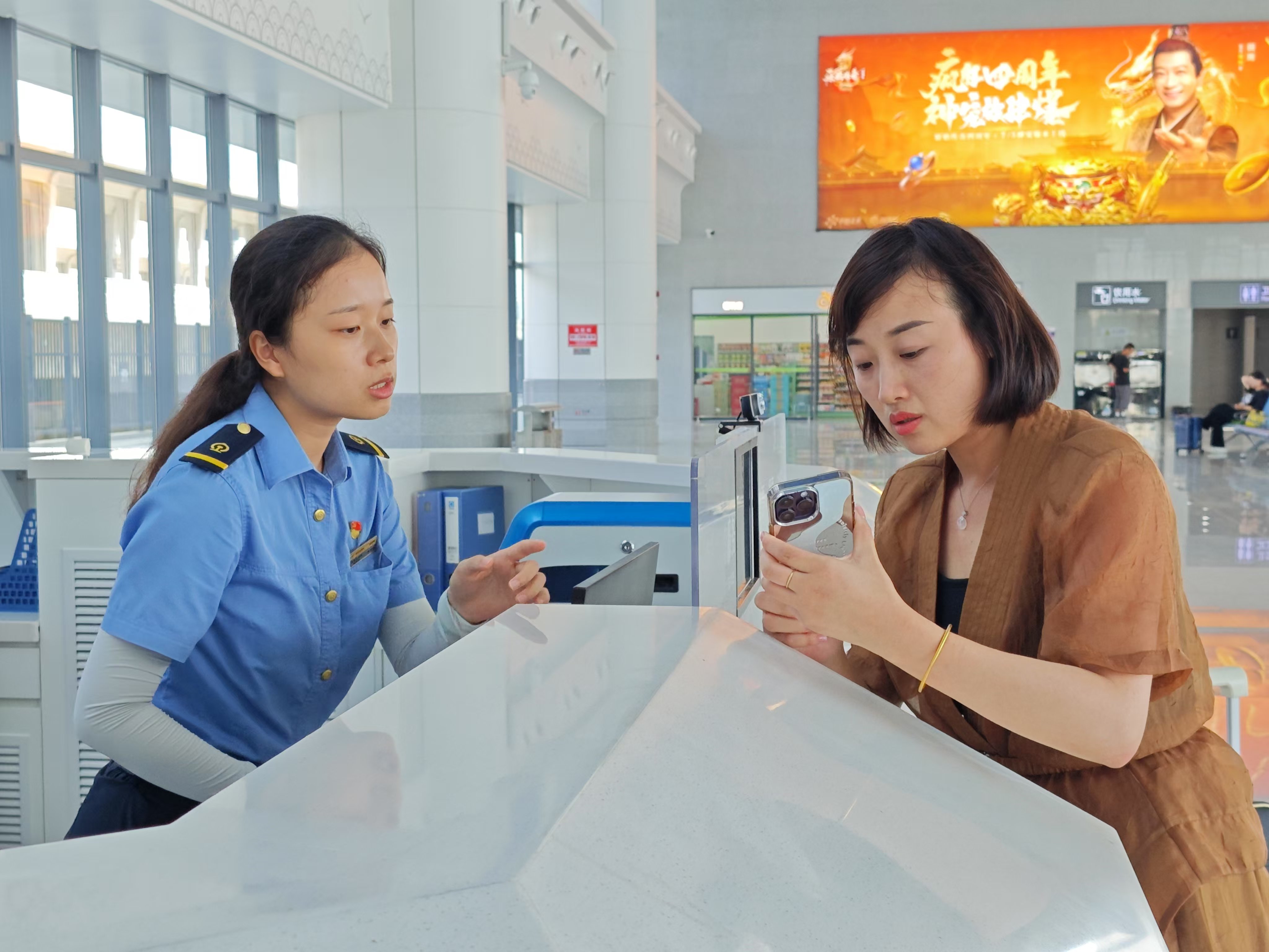 鄱陽站服務臺的工作人員在為旅客解答疑惑。余清清 攝.jpg